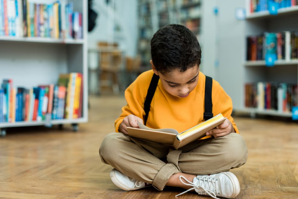 boy reading a book in library