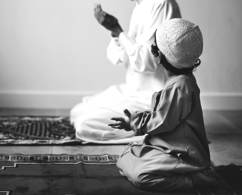 father son on prayer mat